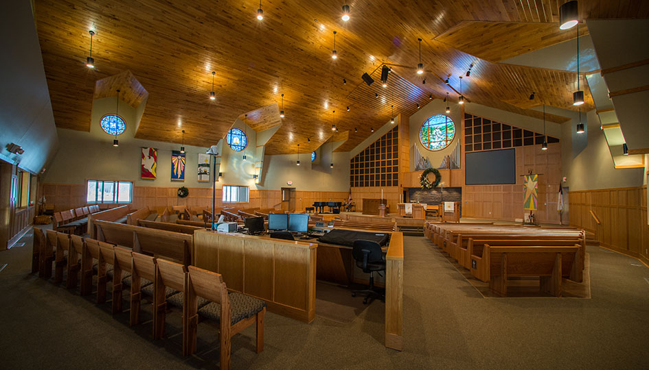 American Lutheran Church worship space with wood ceiling, pews, and chancel area