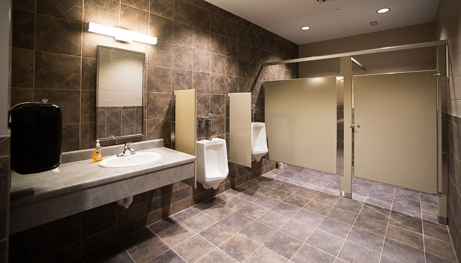 Beverage Wholesalers Alexandria restroom with tile walls, sinks, and stalls