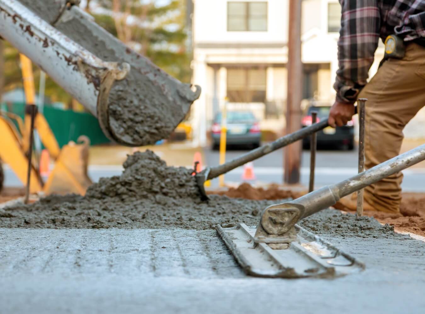 Concrete being poured and leveled at a construction site