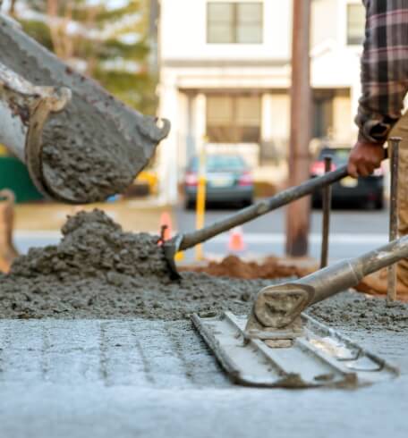 Fresh concrete being poured and finished during construction
