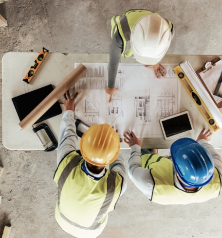 Construction team reviewing building plans at a jobsite table
