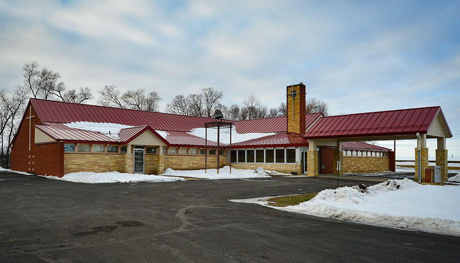 First Presbyterian Church exterior with red metal roof and covered entrance