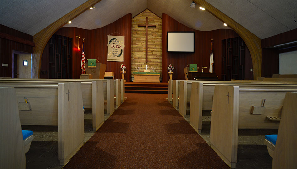 First Presbyterian Church sanctuary with pews, center aisle, and altar