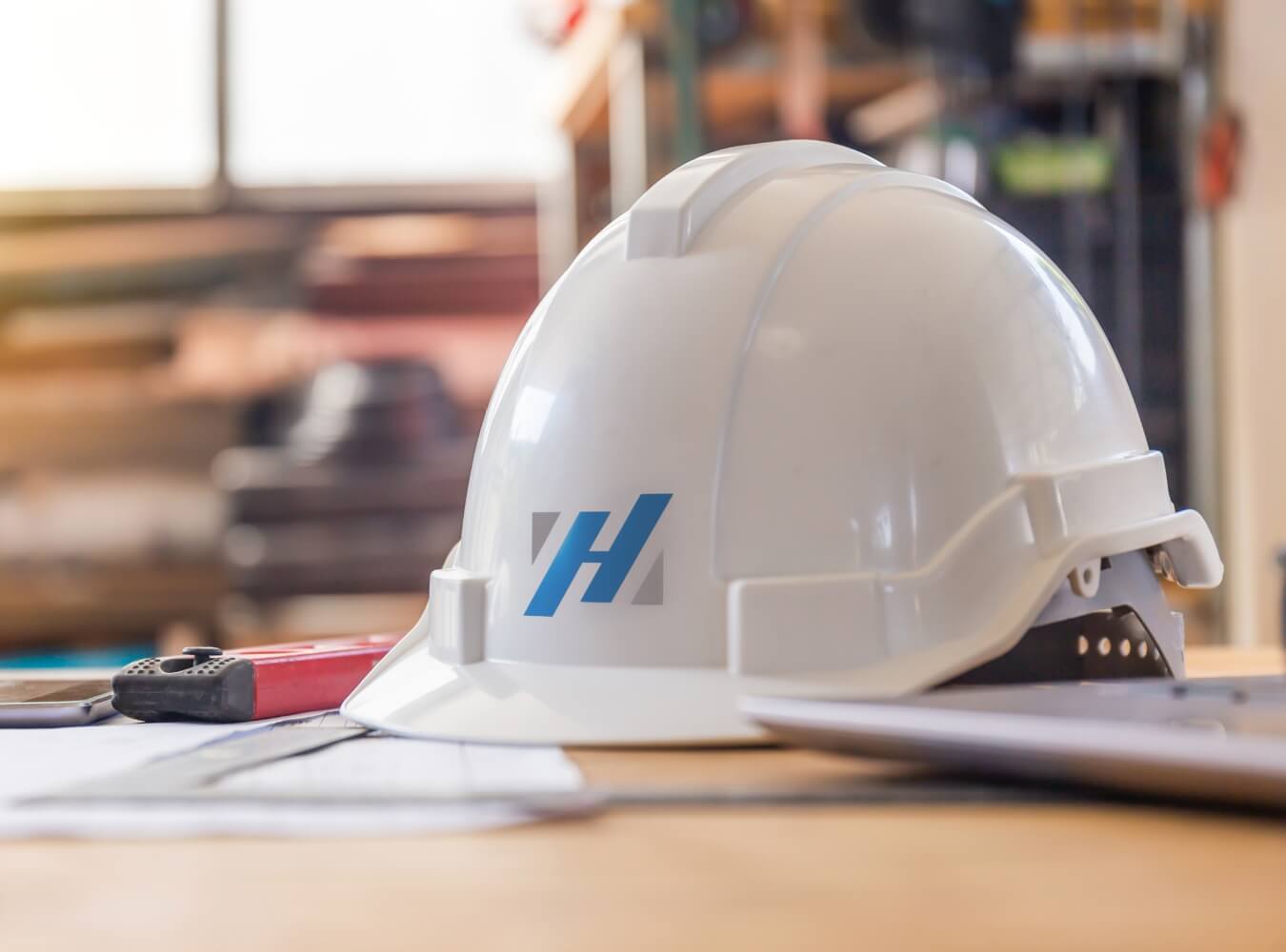 Hasslen Construction hard hat on a jobsite table