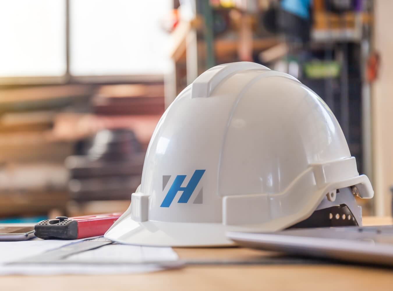 Hasslen Construction hard hat on a jobsite table