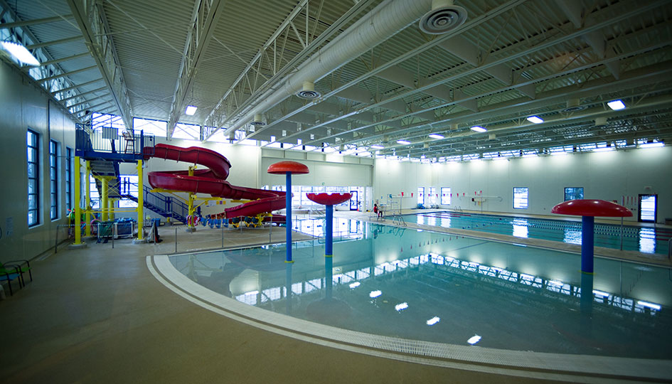 Marshall YMCA indoor pool with waterslide, lap lanes, and splash features