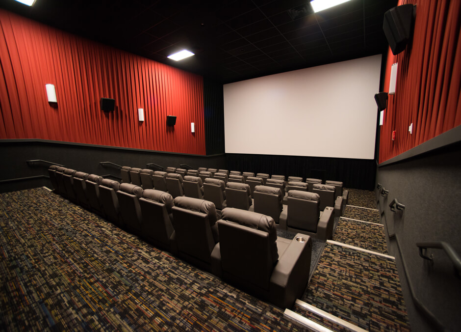 Odyssey Grand 8 Theatre auditorium with rows of recliner seating and movie screen