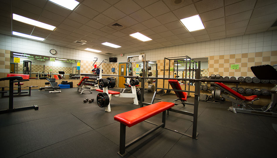 Unity Square fitness room with weight benches, dumbbells, and exercise equipment